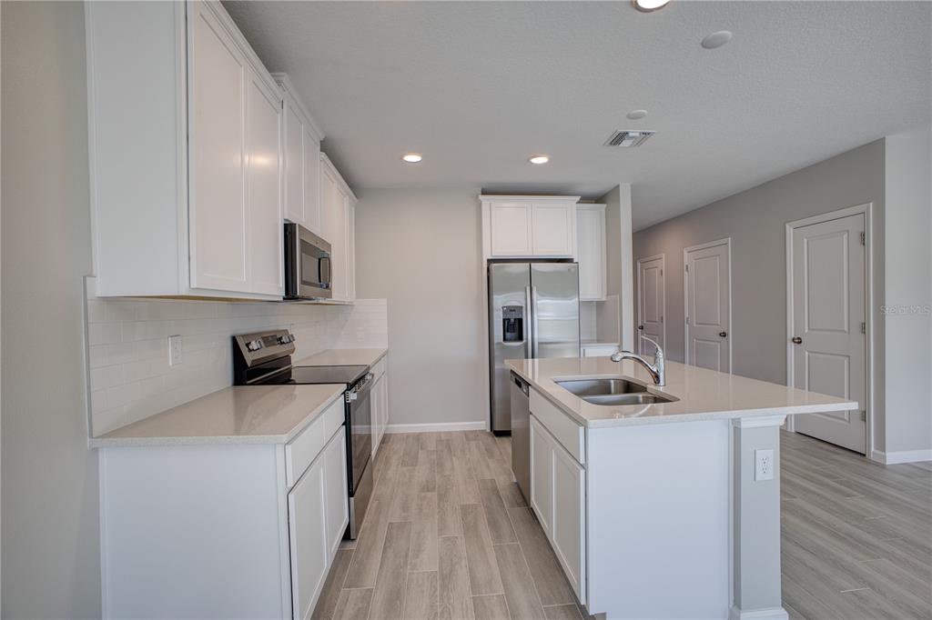 4188 Campsite Loop Orlando, FL 32824 - Photo 8 of 38 a kitchen that has a sink a stove and cabinets