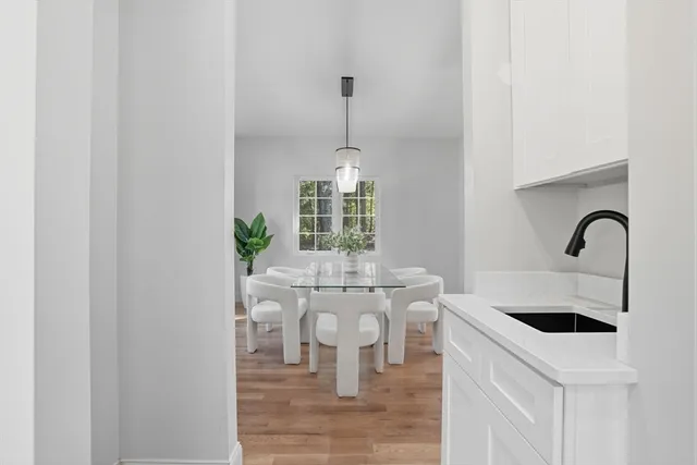 a dining room with furniture potted plants and wooden floor