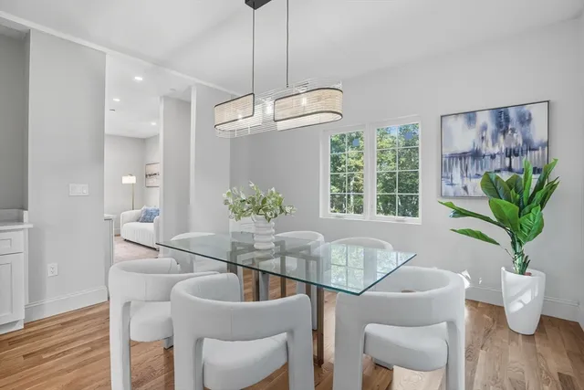 a dining room with furniture a chandelier and wooden floor