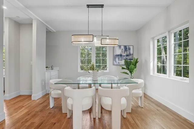 a kitchen with stainless steel appliances kitchen island granite countertop a refrigerator a stove top oven a sink dishwasher and white cabinets with wooden floor