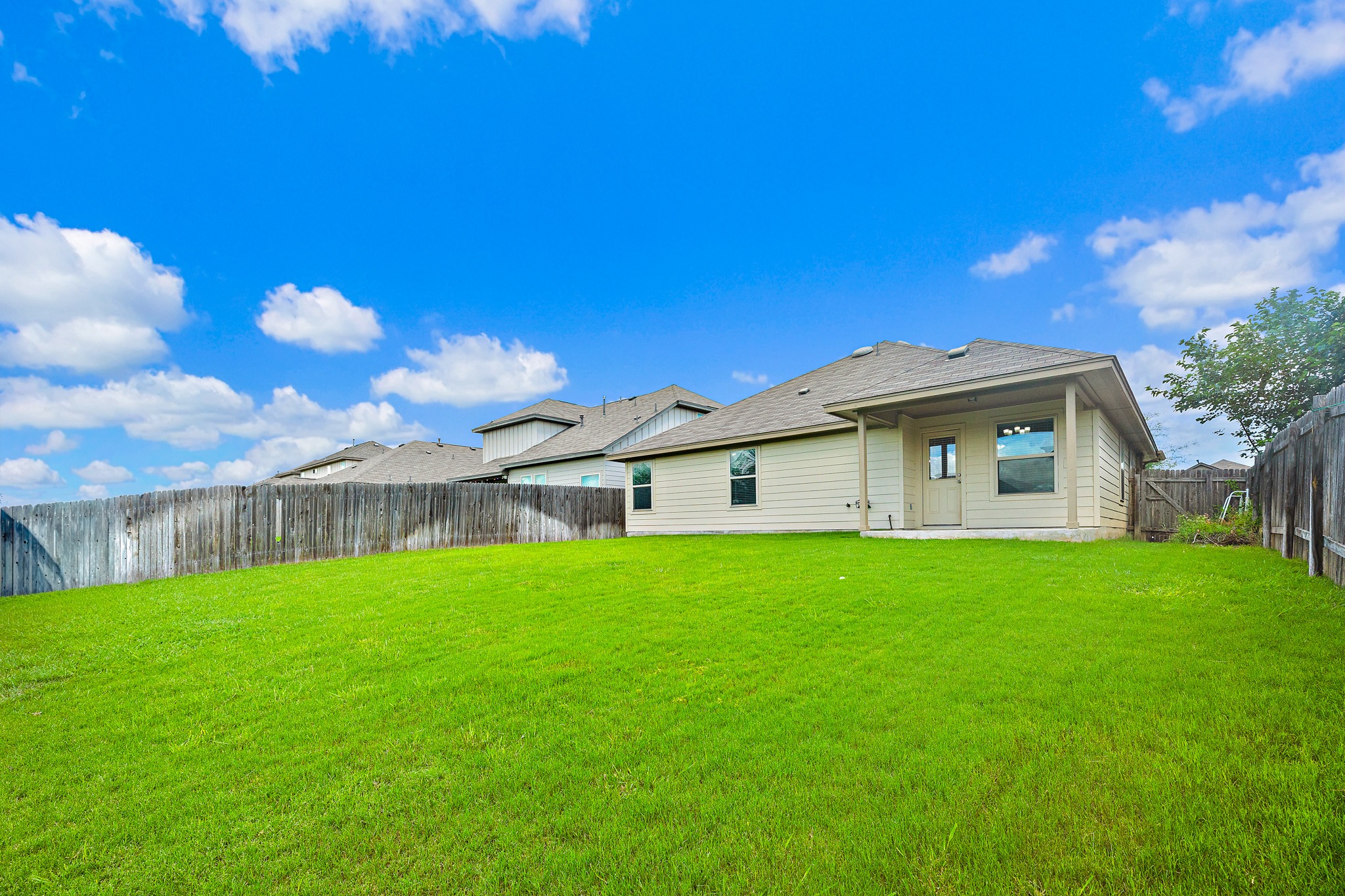 382 Limerick Road Buda, TX 78610 - Photo 20 of 20 A spacious, verdant yard provides ample outdoor living space, enclosed by a privacy fence.