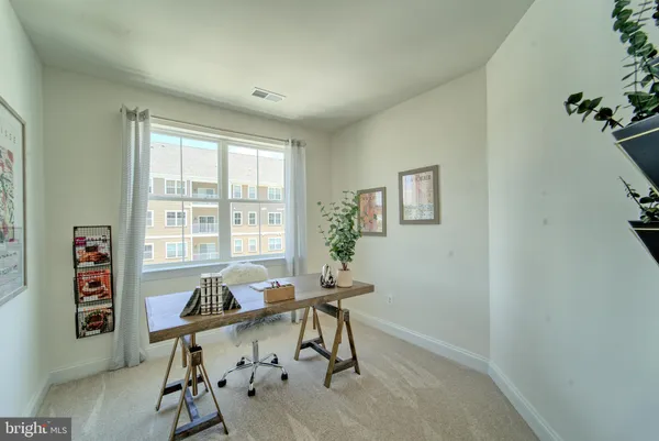 a view of a workspace with furniture and a window