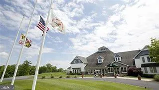a view of white house with a big yard and large trees