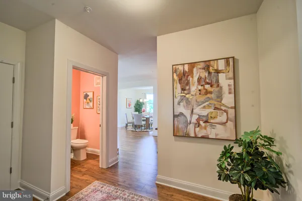 a view of a hallway with wooden floor and a potted plant