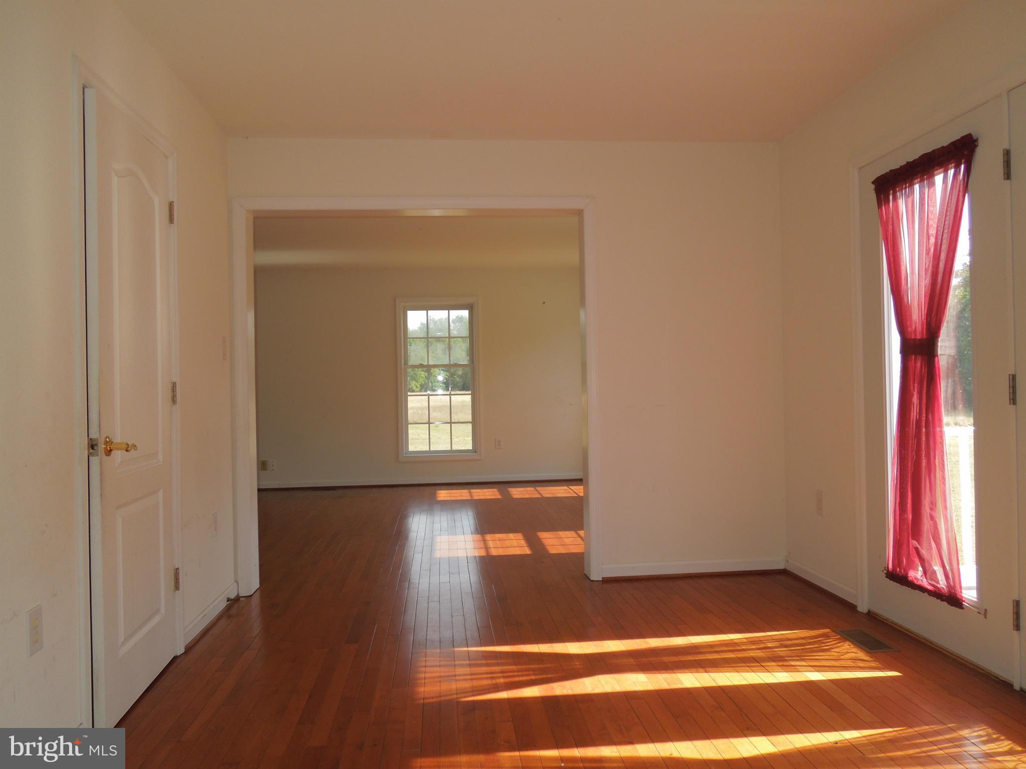 7465 Harmony Road Preston, MD 21655 - Photo 11 of 30 a view of an empty room with window and wooden floor