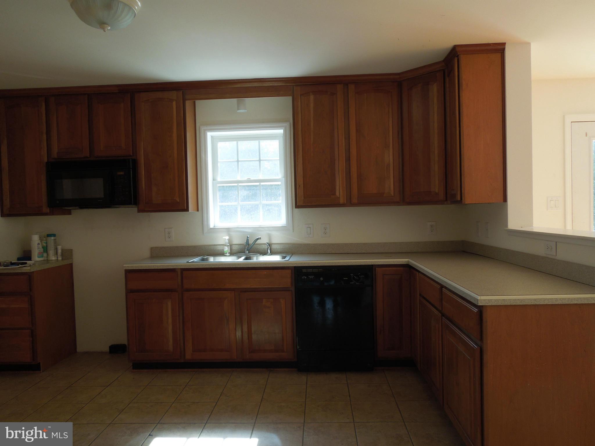7465 Harmony Road Preston, MD 21655 - Photo 8 of 30 a kitchen with stainless steel appliances granite countertop wooden cabinets a sink and a stove