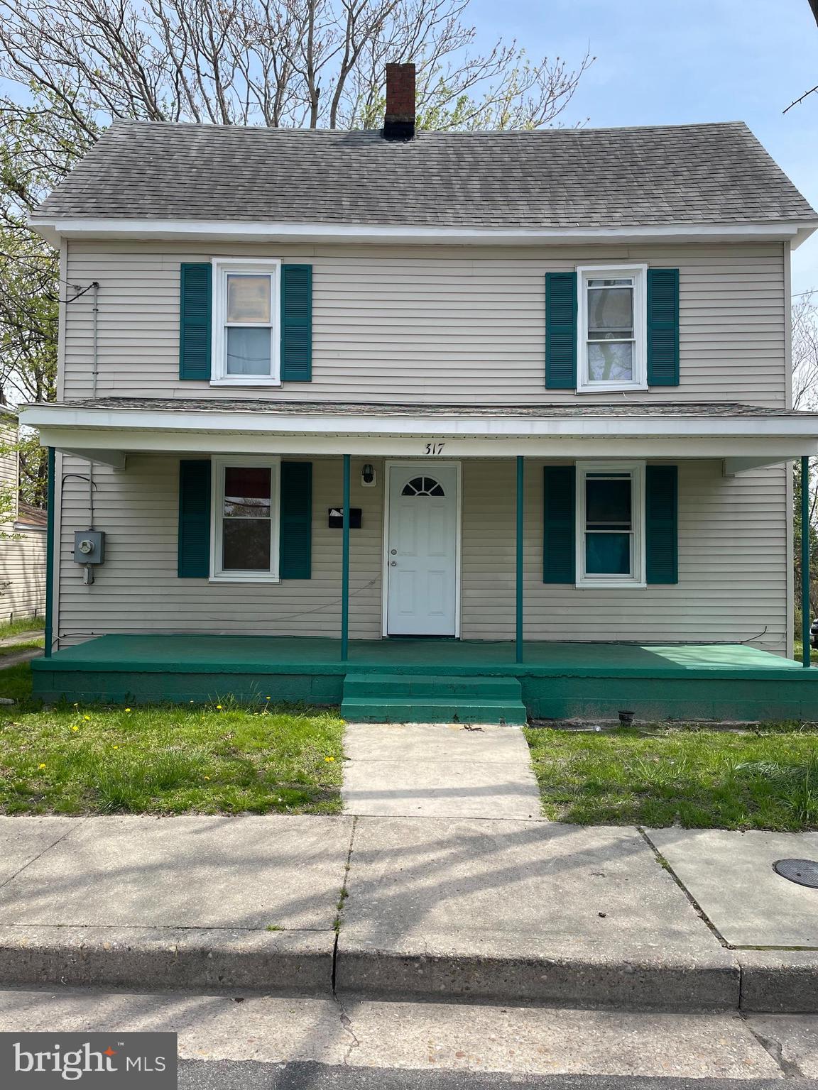 a front view of a house with a garden and yard