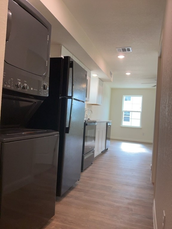 2002 West 2nd Street, Unit 1400 Taylor, TX 76574 - Photo 7 of 14 Kitchen with refrigerator, electric range, microwave, dishwasher, and stacked washer/dryer
