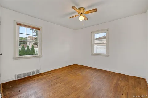 an empty room with a window and a ceiling fan