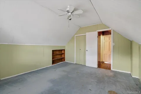 an empty room with a ceiling fan and a window
