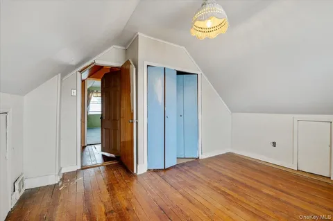 a view of empty room with window and wooden floor
