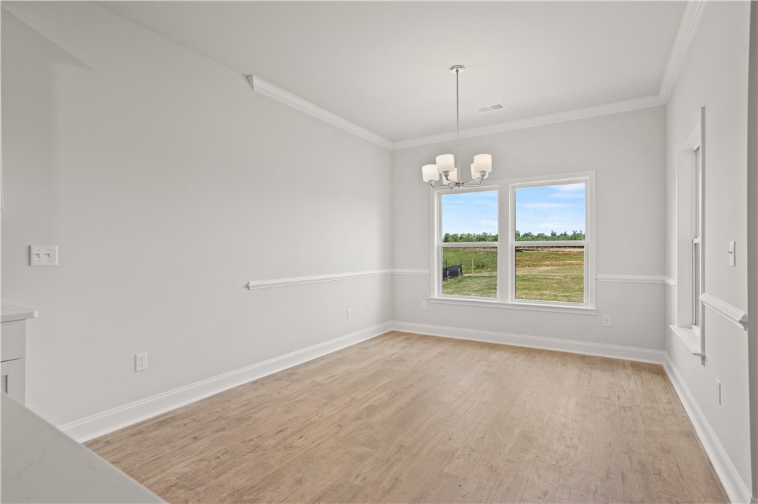 554 Hydrangea Street, Unit LOT 67 Seneca, SC 29678 - Photo 9 of 26 A well-lit room with wood flooring offers an inviting space for gathering.