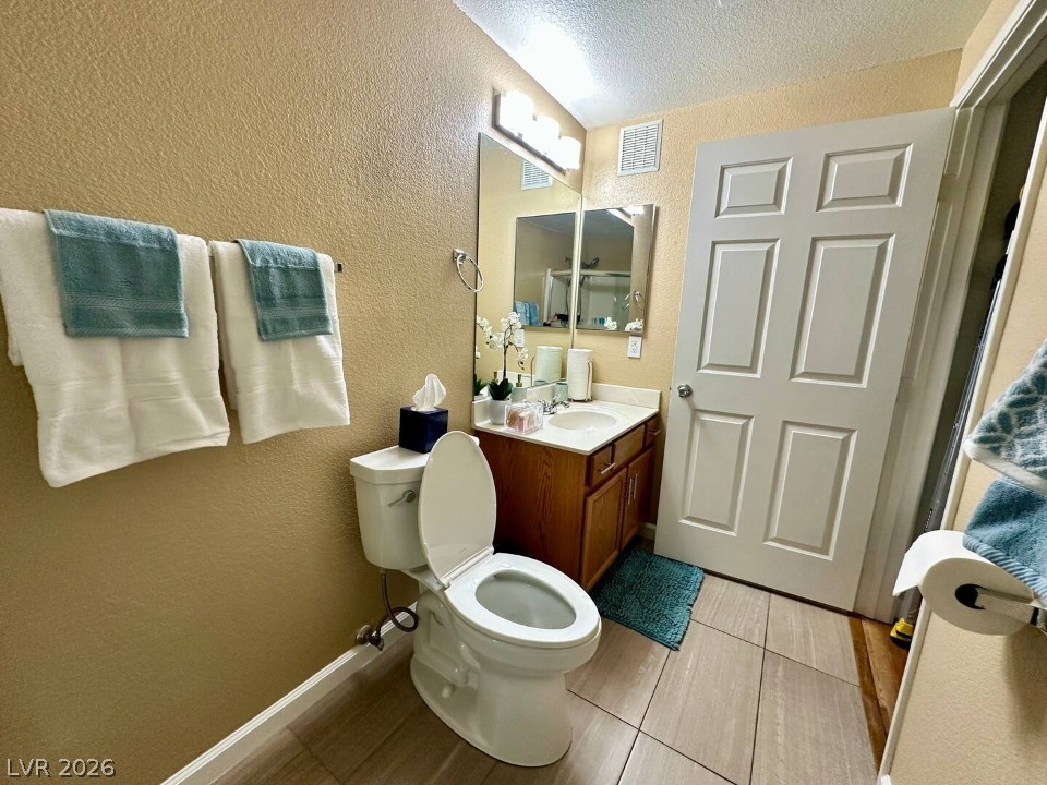 9580 West Reno Avenue, Unit 169 Las Vegas, NV 89148 - Photo 13 of 15 Ceramic tile flooring grounds this well-appointed bathroom, featuring a vanity with sink and a classic toilet.