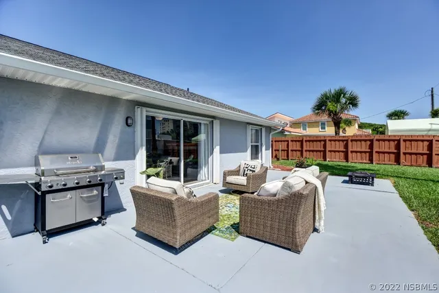 a front view of a house with garden and sitting area