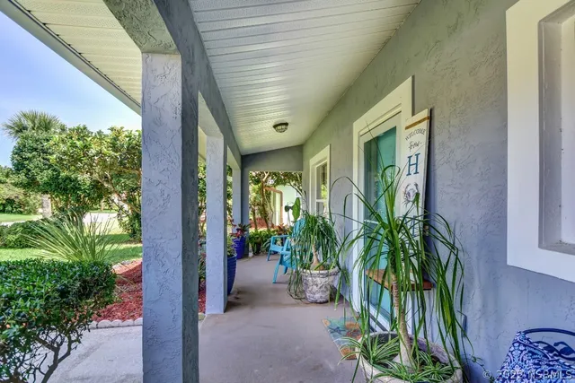a view of a house with a yard and potted plants