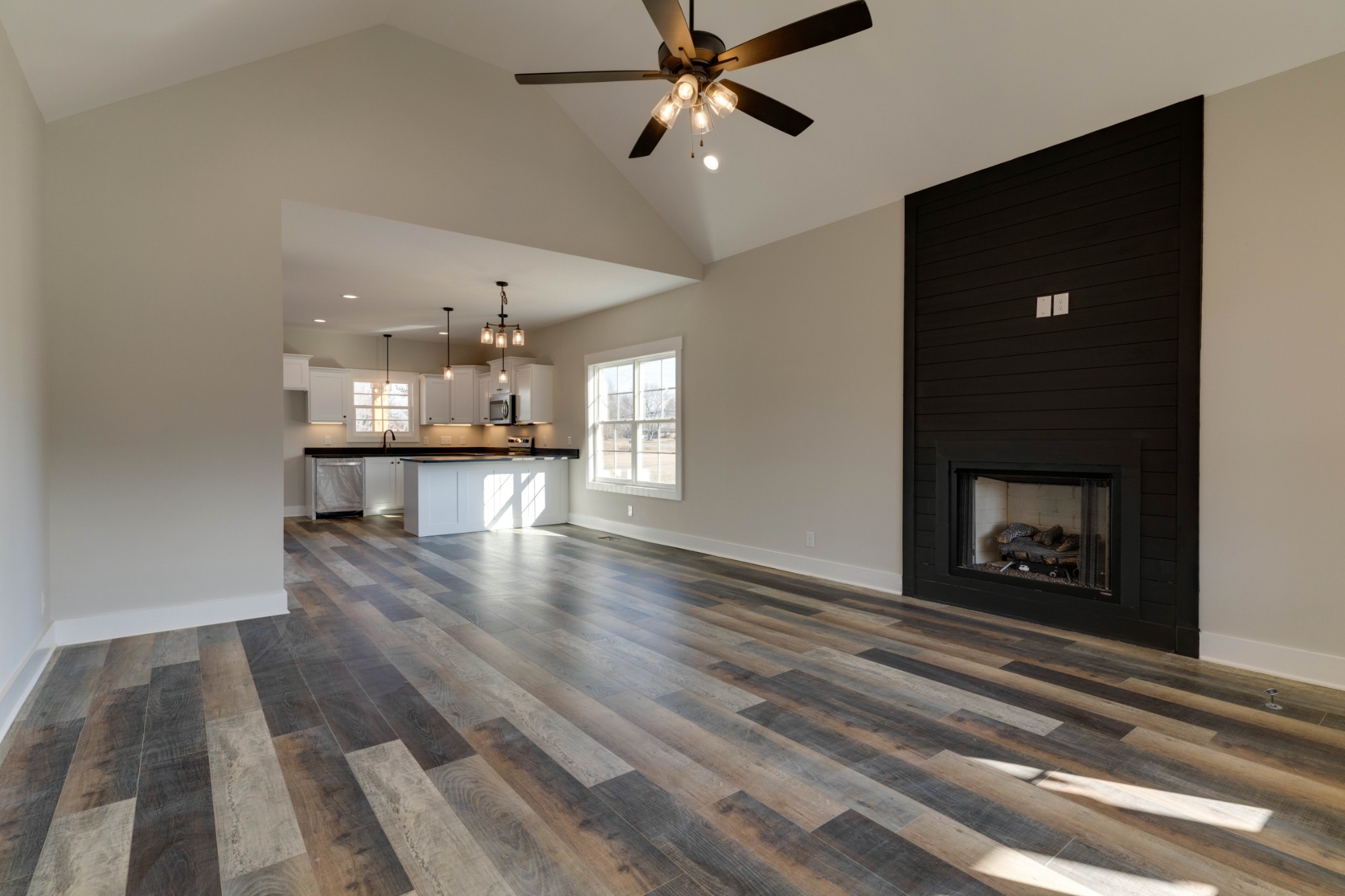155 Julia Ann Court Springfield, TN 37172 - Photo 3 of 17 an empty room with wooden floor a ceiling fan and a fireplace