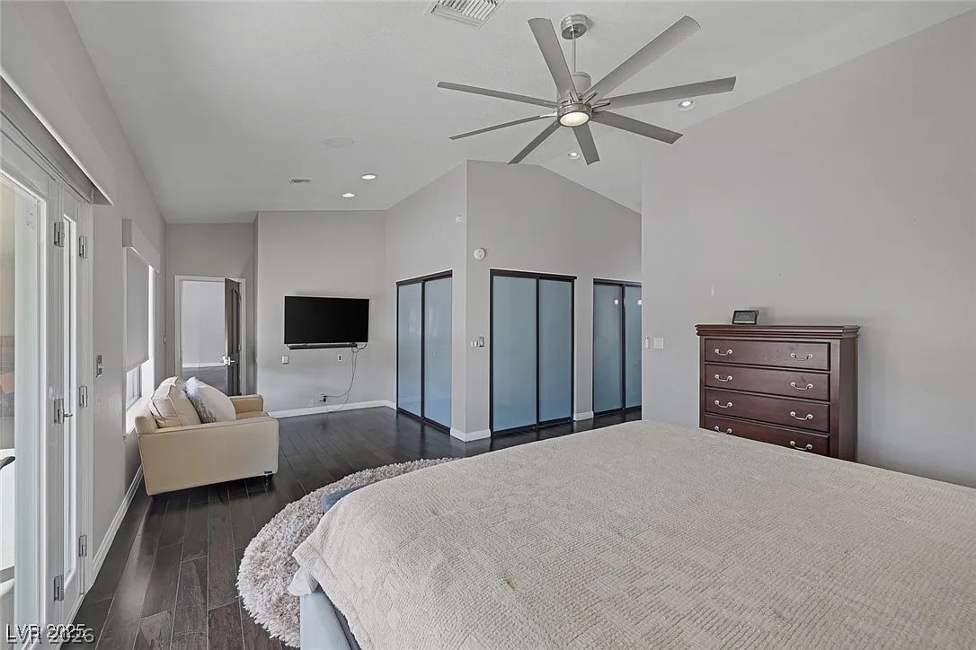 9 Quail Run Road Henderson, NV 89014 - Photo 26 of 57 Hardwood floors and a vaulted ceiling elevate this primary bedroom's contemporary appeal.