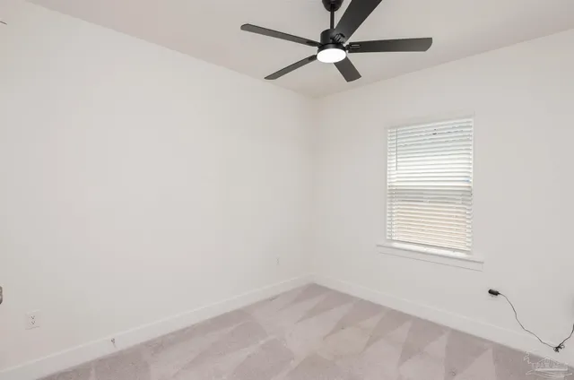 an empty room with a window and a fan