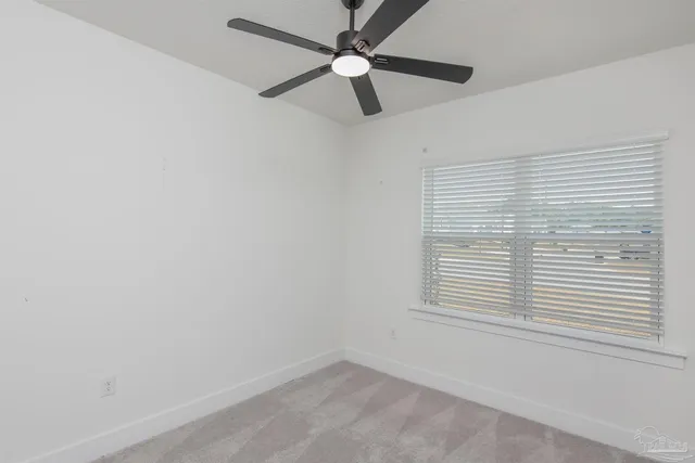 an empty room with a window and a fan