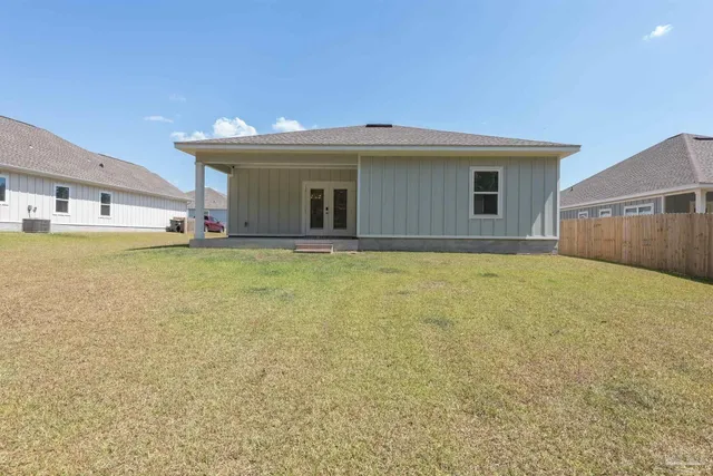 a view of a house with a backyard and a tree