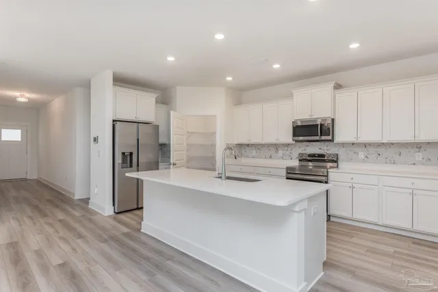 a kitchen with stainless steel appliances a refrigerator stove microwave and sink