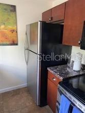 3206 West Azeele Street, Unit 220 Tampa, FL 33609 - Photo 6 of 9 a kitchen with a refrigerator and a stove