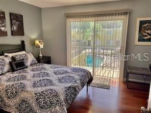 3206 West Azeele Street, Unit 220 Tampa, FL 33609 - Photo 8 of 9 a bedroom with a bed and wooden floor