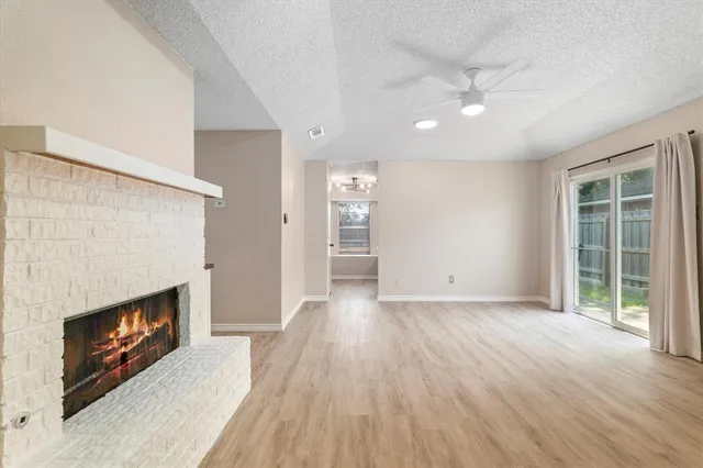 a view of hallway with a window and wooden floor