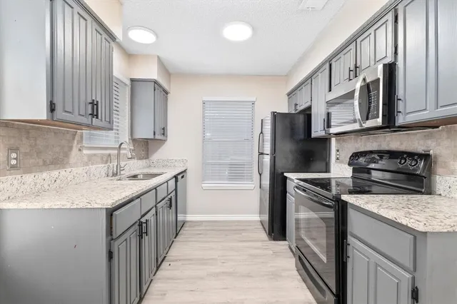 a kitchen with stainless steel appliances granite countertop a sink stove and refrigerator