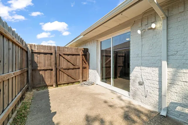 an empty room with wooden floor and fan