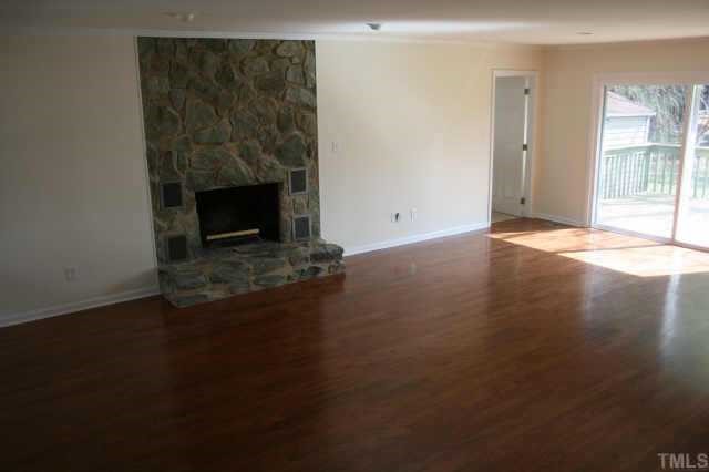 4204 Frost Court Raleigh, NC 27609 - Photo 2 of 6 Open living room area with stone fireplace and new hardwood floors.