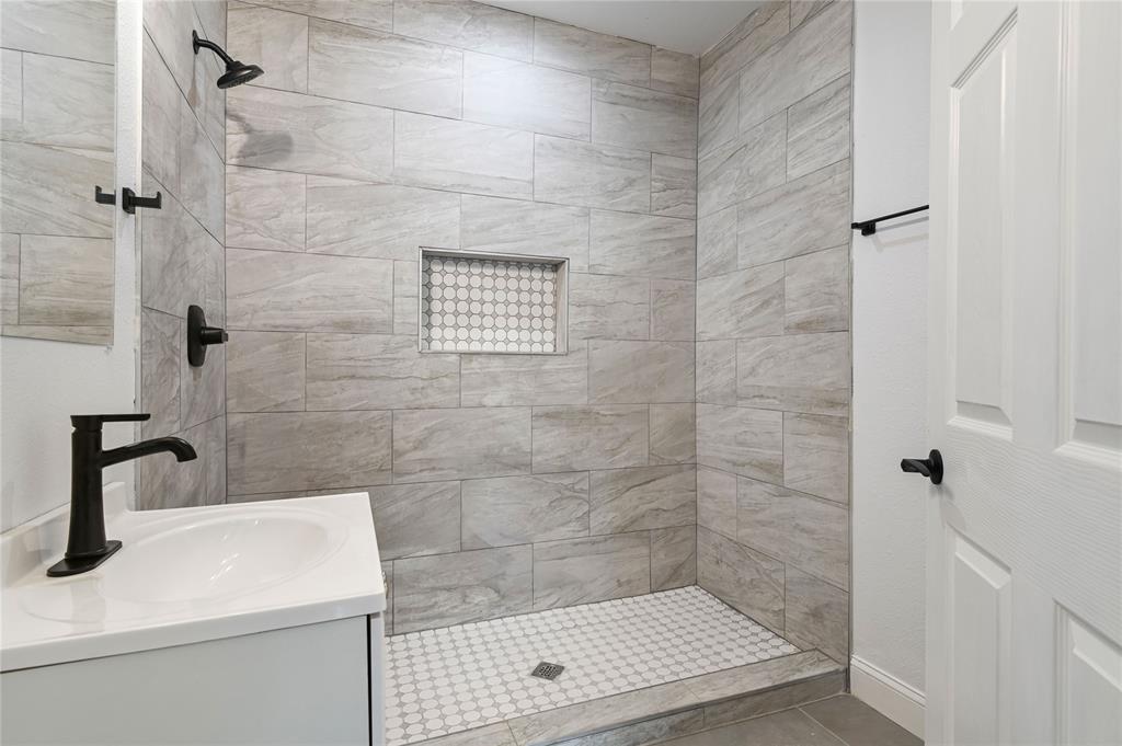 1106 West Chestnut Street Denison, TX 75020 - Photo 5 of 38 Bathroom with vanity, a tile shower, and tile patterned floors