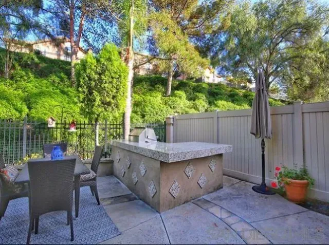 a view of a patio with table and chairs potted plants and large tree