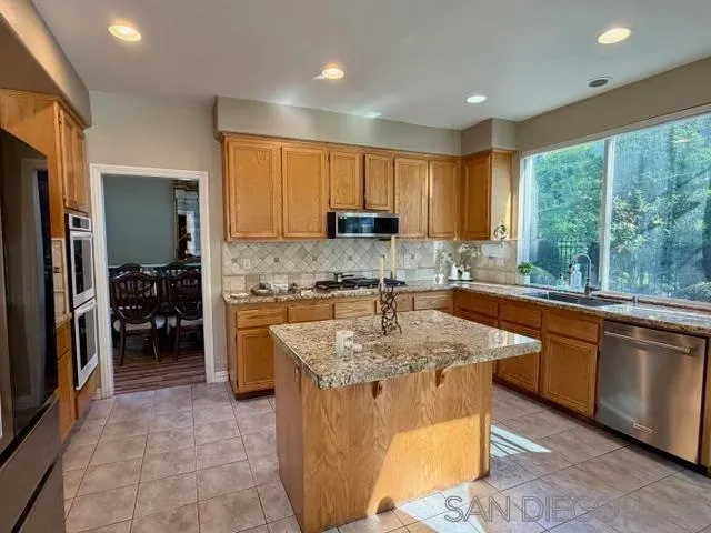 a kitchen with stainless steel appliances granite countertop a stove a sink a microwave and a refrigerator