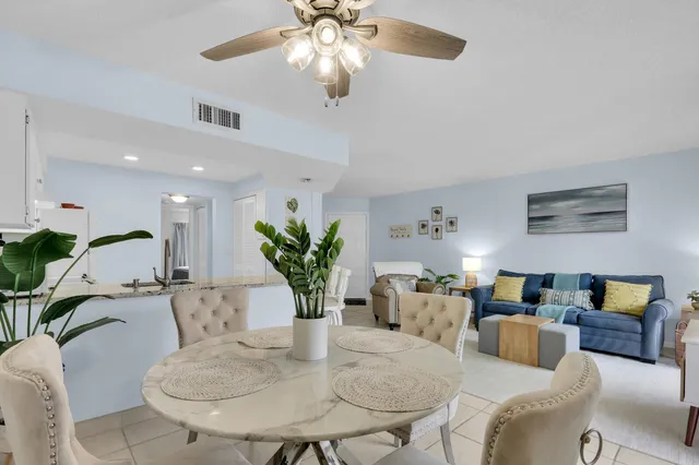 a living room with furniture chandelier and a potted plant