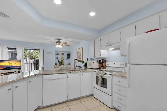 a kitchen with white cabinets and white appliances