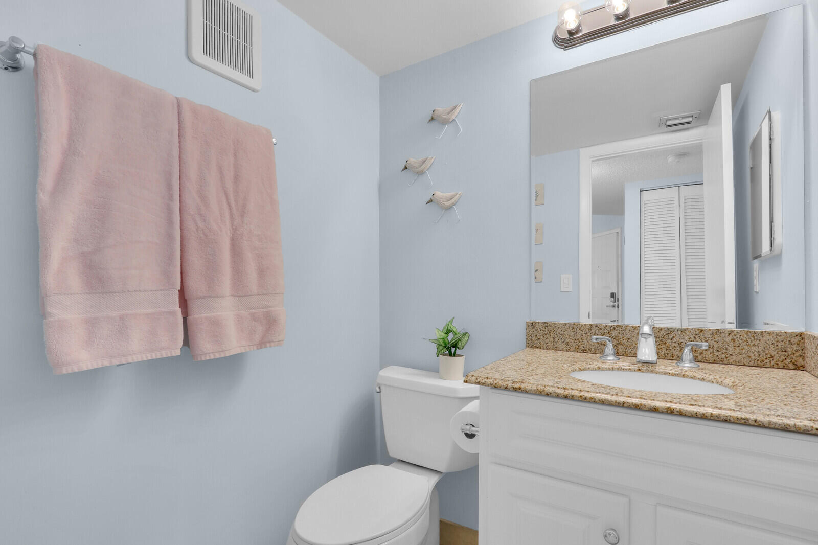 1605 Highway 1, Unit A204 Jupiter, FL 33477 - Photo 16 of 32 a bathroom with a granite countertop sink a toilet and mirror