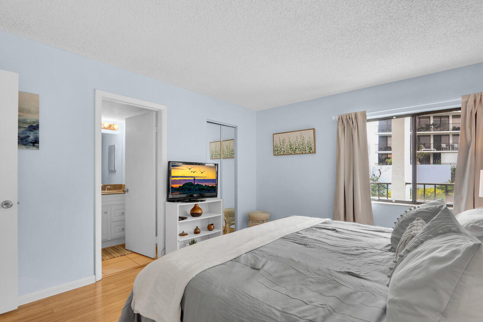 1605 Highway 1, Unit A204 Jupiter, FL 33477 - Photo 18 of 32 a bedroom with a bed and a flat screen tv