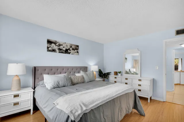 a bedroom with a bed and wooden floor