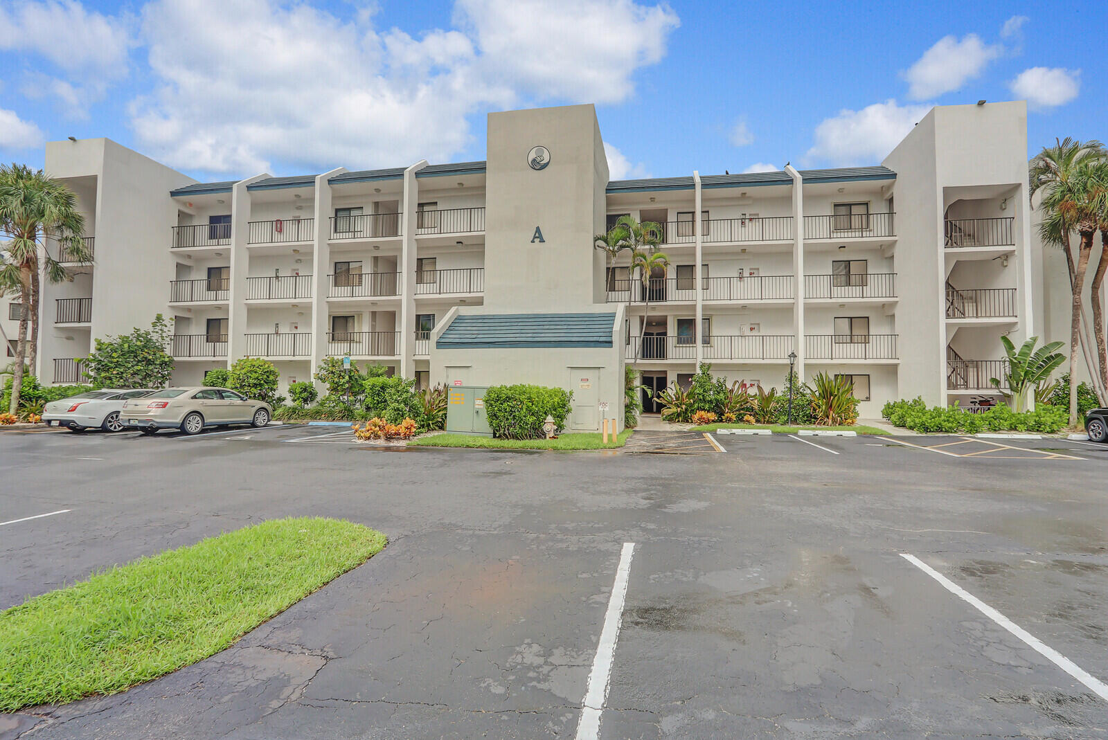 1605 Highway 1, Unit A204 Jupiter, FL 33477 - Photo 2 of 32 a front view of a building with a garden and plants