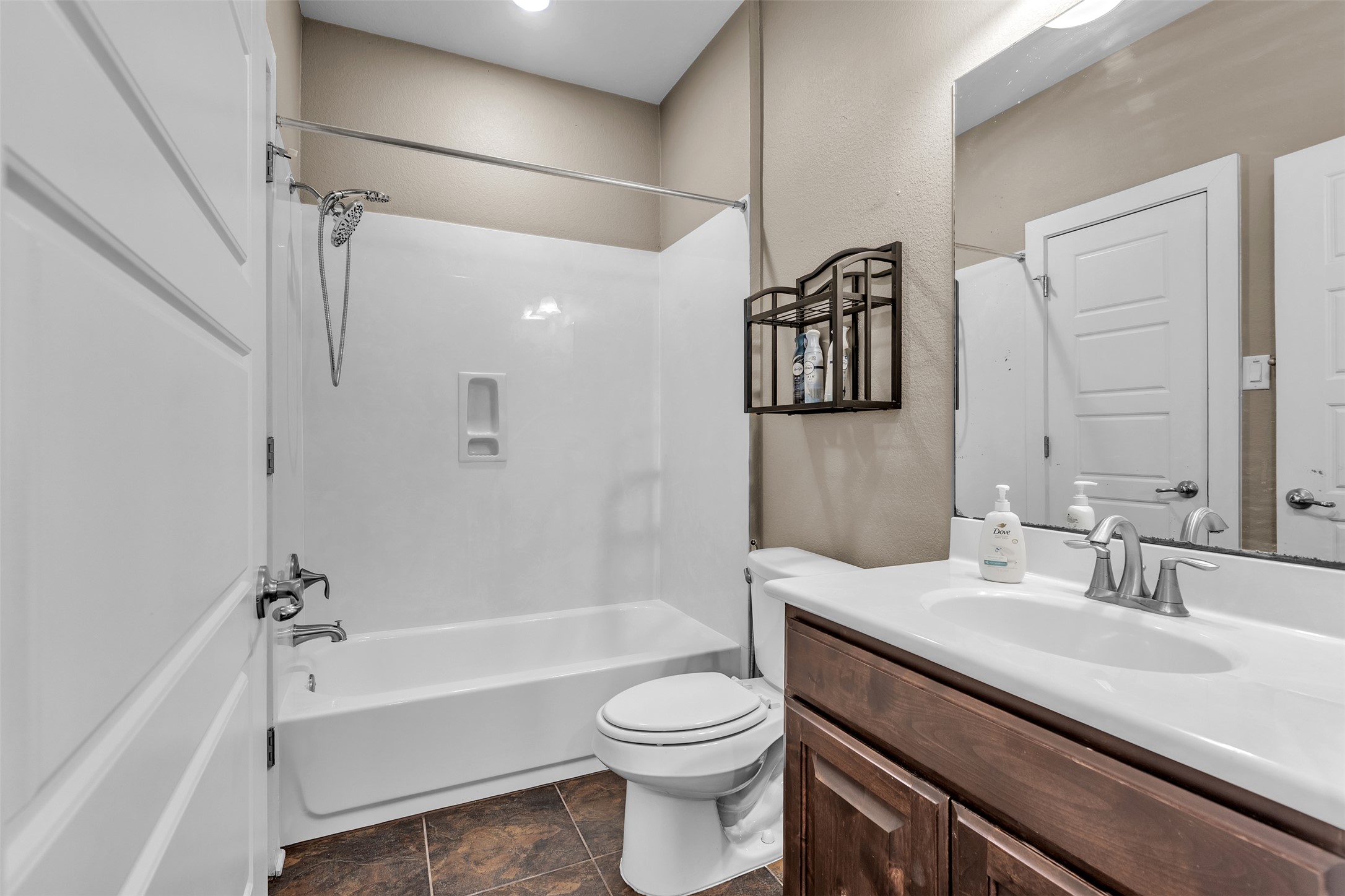12212 Tawny Farms Road, Unit 142 Austin, TX 78748 - Photo 4 of 21 A well-appointed bathroom offers a clean tub-shower combination, a functional vanity, and dark tile flooring.