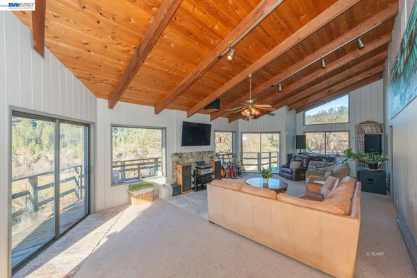 a living room with furniture a flat screen tv and a large window