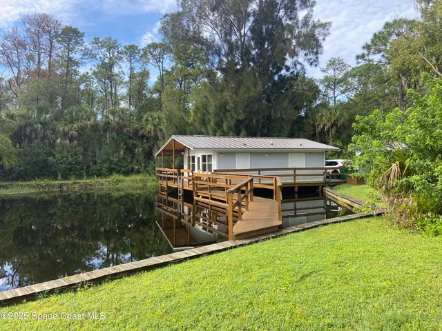 an aerial view of a house with swimming pool a yard and a fountain