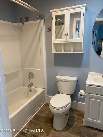 a white toilet sitting next to a bath tub