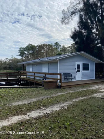 a backyard of a house with barbeque oven