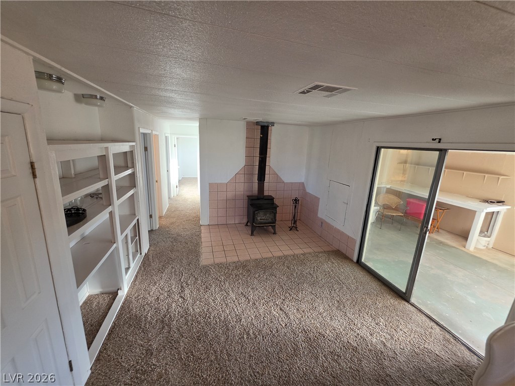 2930 Frehner Ranch Road Pioche, NV 89043 - Photo 17 of 32 A cozy living space features a rustic wood-burning stove and direct access to an enclosed patio.