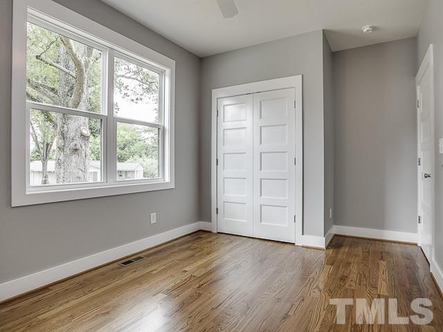 1002 Caspan Street Raleigh, NC 27610 - Photo 18 of 25 an empty room with wooden floor and windows
