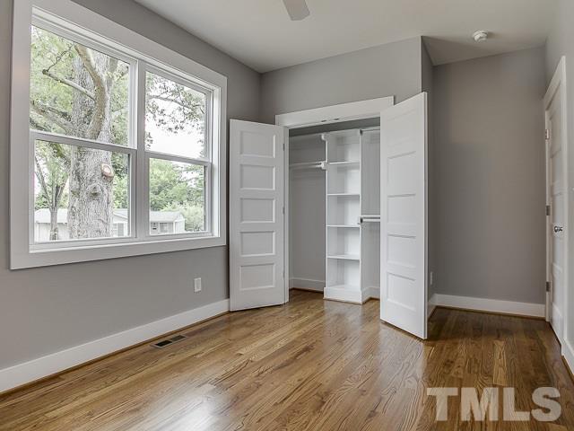 1002 Caspan Street Raleigh, NC 27610 - Photo 19 of 25 an empty room with wooden floor closet and windows