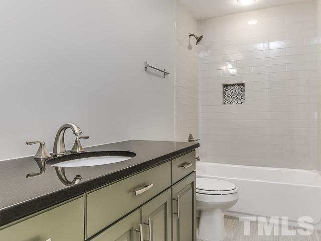 1002 Caspan Street Raleigh, NC 27610 - Photo 20 of 25 a bathroom with a granite countertop sink a toilet and shower