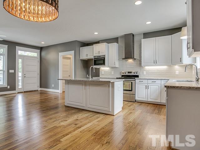 1002 Caspan Street Raleigh, NC 27610 - Photo 6 of 25 a kitchen with stainless steel appliances granite countertop a stove a sink and a microwave